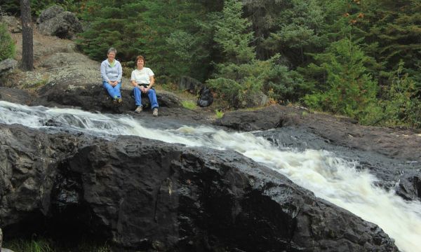 couple sitting next to a waterfall