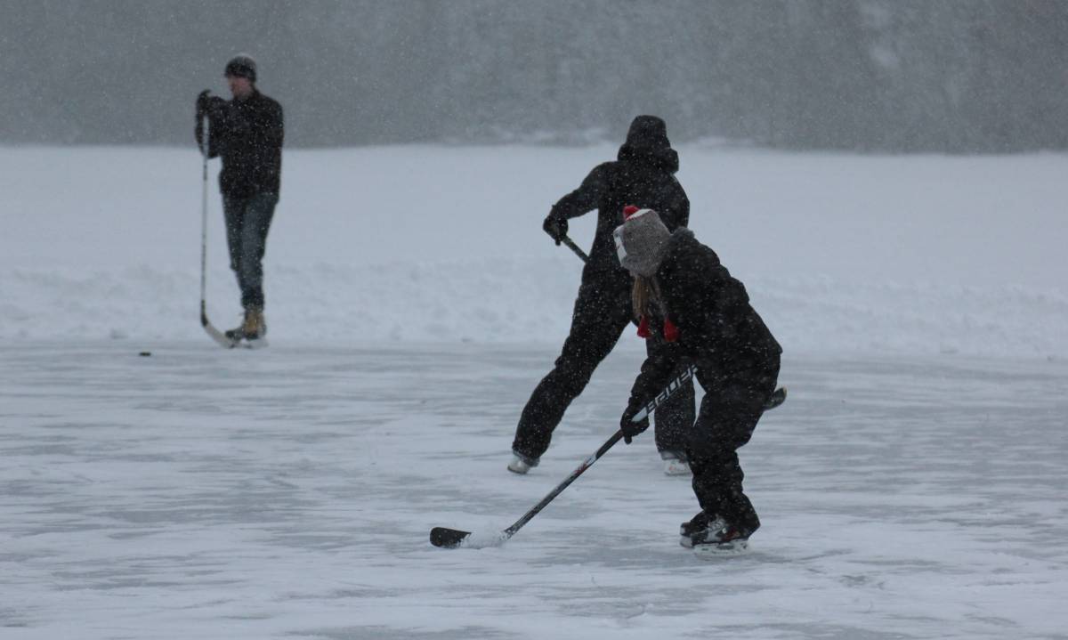 People playing hockey on lake ice