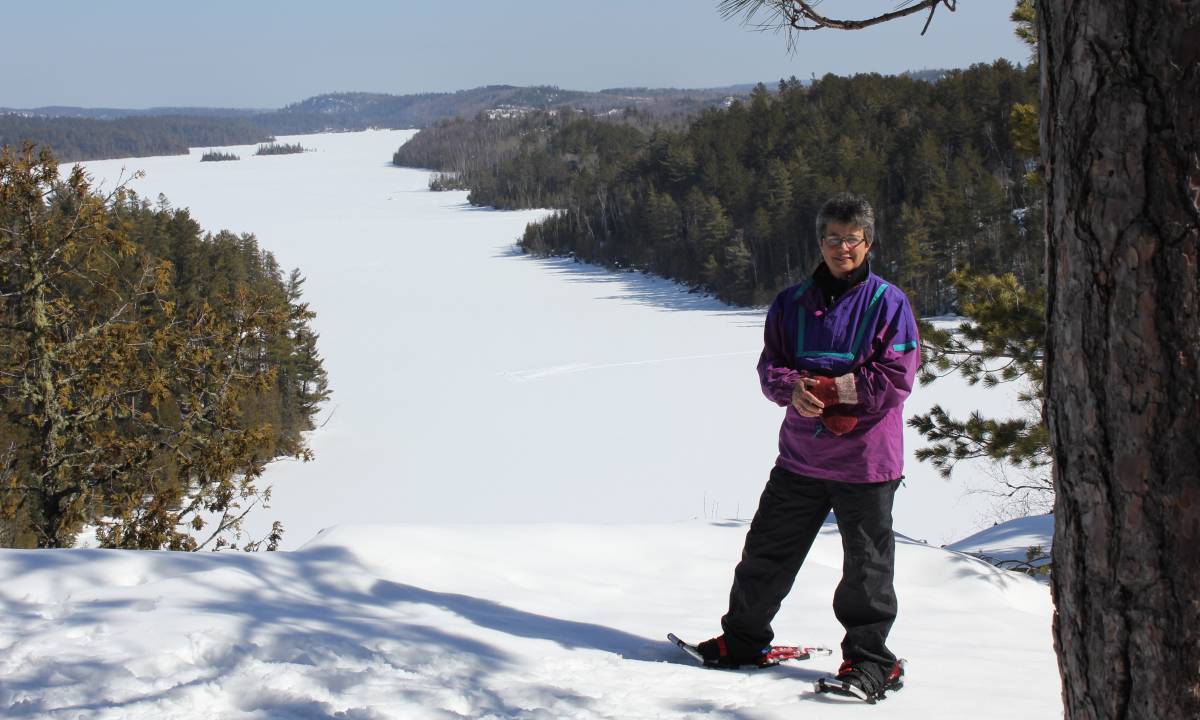 Woman in snowshoes overlooking the lake.