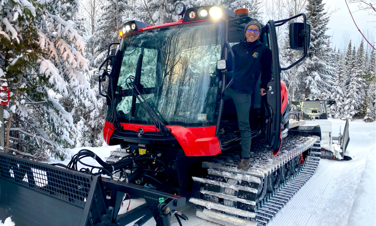 Ruth standing on the Trail Grooming vehicle