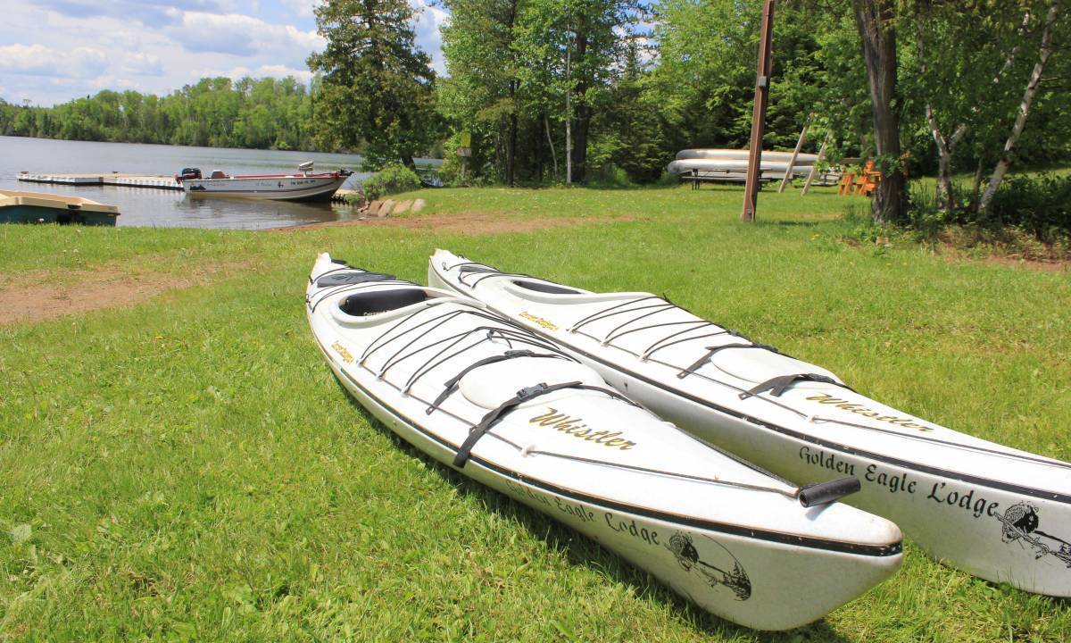 two kayaks on grass shore